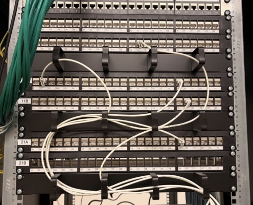 Nytt kontorsnätverk med UniFi på Djurgården 3 UniFi Cloud Gateway Fiber och PoE-switch i rack med märkta patchpaneler på kontor på Djurgården