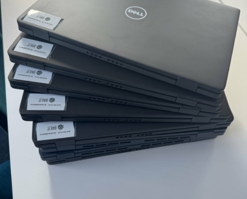Stapel med nya Dell-datorer märkta med DAX IT-etiketter, förberedda med Intune inför utrullningen på Djurgården