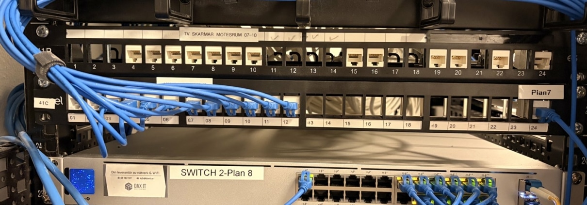 Wi-Fi 7 på tre kontorsvåningar: 32 accesspunkter och en PoE-kalkyl 1 UniFi Pro 24 PoE-switch märkt Plan 8 under patchpaneler i kontorets nätverksrack i Hornstull