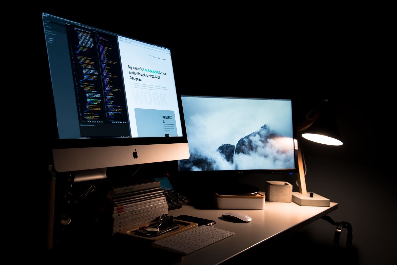 Arbetsplats med Mac och extra skärm som visar kod