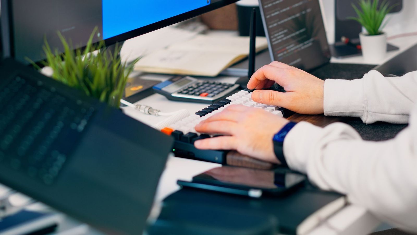 Person arbetar vid tangentbord på ett modernt kontor