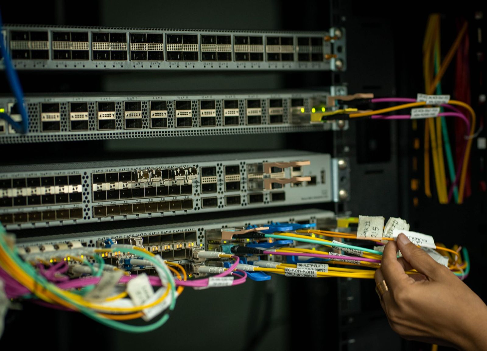 Tekniker kopplar in fiberkablar i ett nätverksskåp